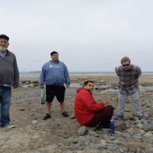 Four of The Arc of Lincoln County participants pose for a picture on a rocky beach during a beach walk